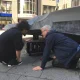 Behrooz Moosavi and Ronald Gaube positioning a speaker under the sculpture CHIP