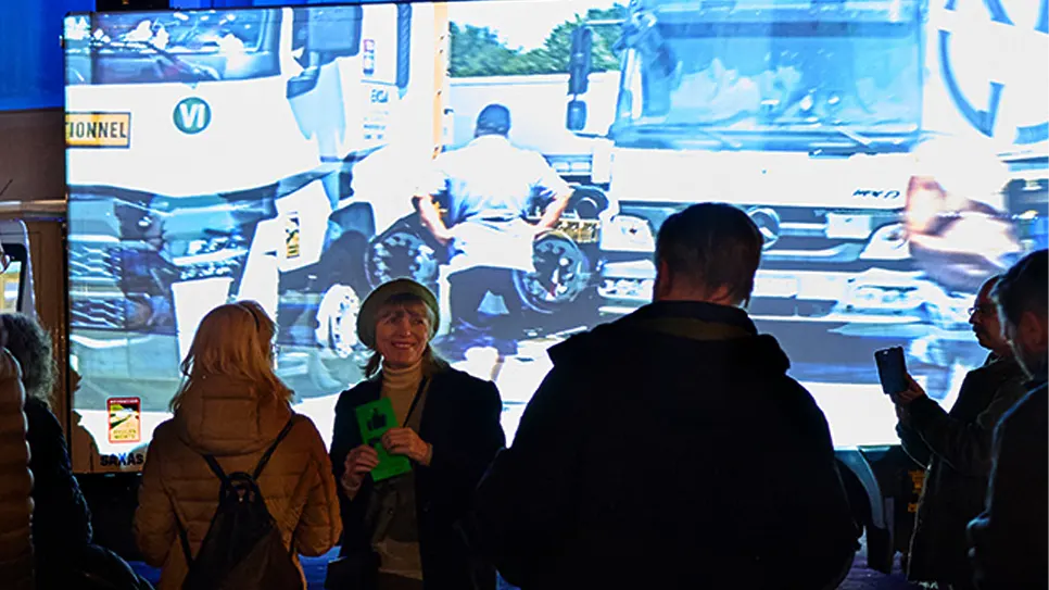 Die Oberbürgermeisterin von Gelsenkirchen, Karin Welge, bei der Eröffnung des Goldstücke Festivals. In der Hand hält sie den Aufkleber von WHEELS, im Hintergrund ist die Video-Klang-Installation der Area Composer zu sehen.
